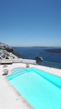 White architecture in Santorini island, Greece. Luxury swimming pool with blue water. Blue sea and the blue sky at sunny day. Travel and summer vacation concept. Vertical video
