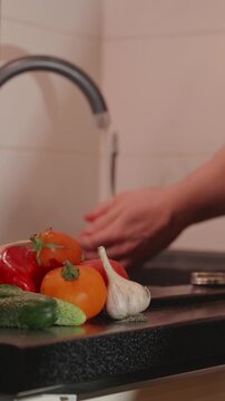 Hand picking fresh garden tomato and rinsing under water
