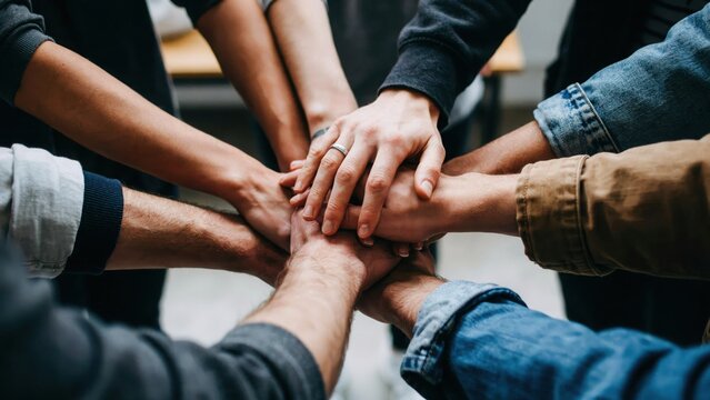 Close up of hands stacked together in unity diverse group showing teamwork and togetherness for support and collaboration.