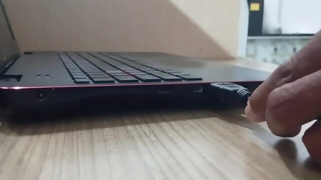 Close-up footage of a person connecting an HDMI cable to a laptop. Technology concept showing display connection, external monitor setup, and digital device connectivity in Full HD.