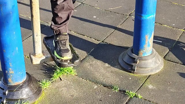 Close up of legs using outdoor elliptical trainer. Street workout and fitness equipment in public park. Person exercising on cross trainer