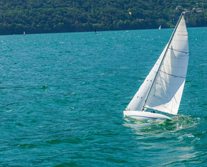 White Sailboat Glinding Across Lake Como on a Sunny Summer Day © Irina
