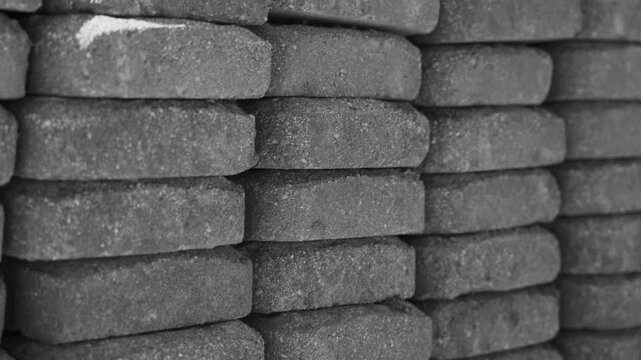 Camera moving laterally upward over the stacked bricks in black and white.