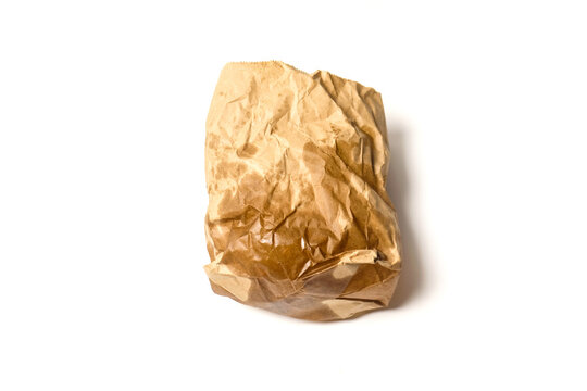 A crumpled brown paper food bag stained with grease spots, standing upright against a plain white background.