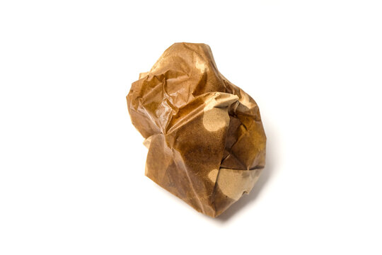 A balled-up, greasy brown paper wrapper sitting on a clean white surface after use.