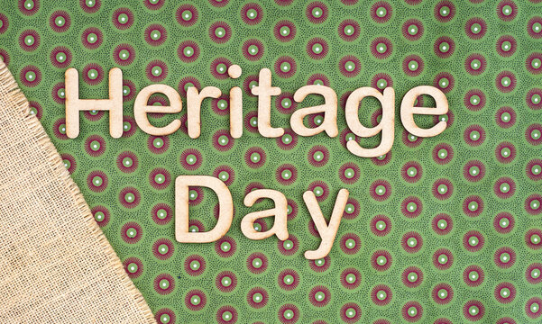 Heritage Day wooden lettering on traditional green shweshwe fabric background