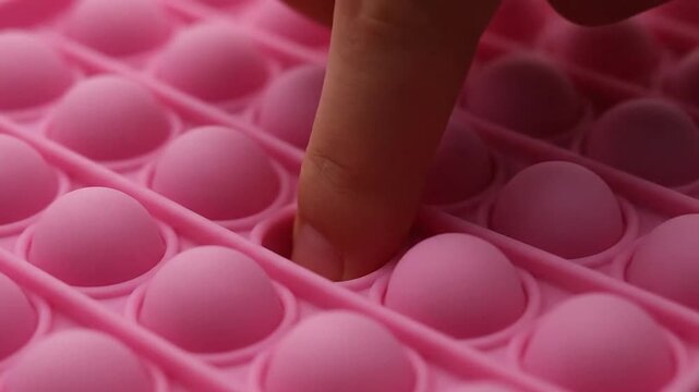 Pink silicone sensory fidget toy with round bubbles macro