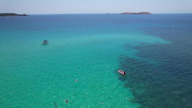 Aerial drone view of a powerful speed boat gliding across crystal-clear turquoise water, creating a striking white wake. Perfect representation of luxury travel, freedom, summer adventure.