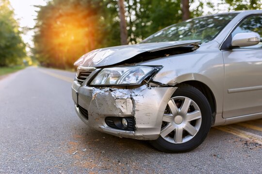 The Damaged Sedan on the Roadside After a Front End Collision