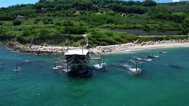 Frontal aerial of a fishing hut's net rigging at the beach 4k drone