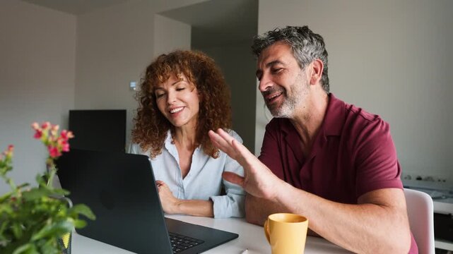 Mature couple waving and blowing kisses during a video call
