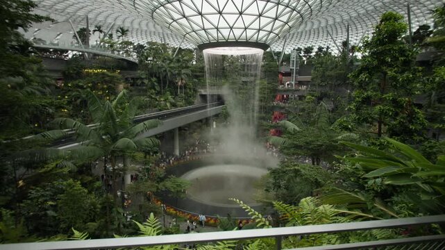 Modern Singapore airport featuring breathtaking bionic architecture indoor tropical gardens and a stunning waterfall creating a world famous travel destination in Asia