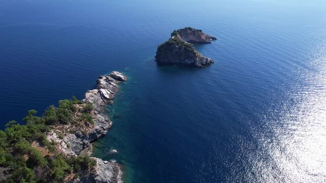 Beautiful aerial view of a sandy beach with crystal clear sea, turquoise water and visitors enjoying swimming and paddleboarding on Thassos Island, Greece.