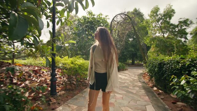 Tourist walking through Singapore Botanic Gardens surrounded by beautiful tropical plants and lush greenery in a peaceful urban oasis for travel in Asia