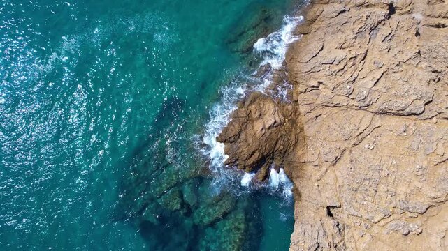 Aerial drone of a peaceful beach in Thassos, Greece, featuring transparent turquoise water, paddleboards, swimmers and a beautiful Mediterranean coastline.