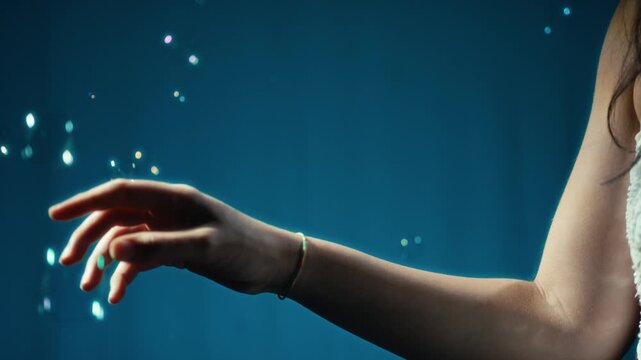A womans hand touches dreamily the soap bubbles rising upwards