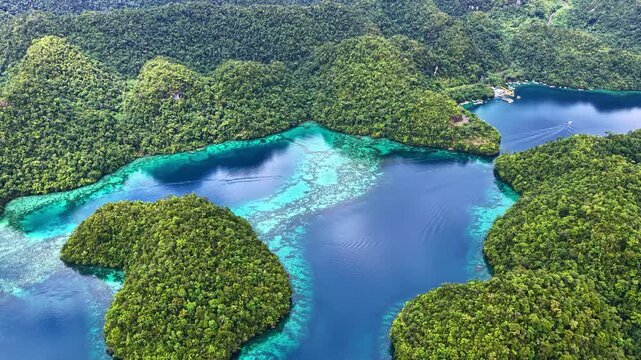 Aerial view of a tropical lagoon with turquoise water surrounded by lush green islands and dense vegetation in the Philippines.