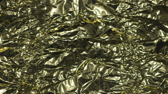 Golden crumpled foil abstract texture background pattern