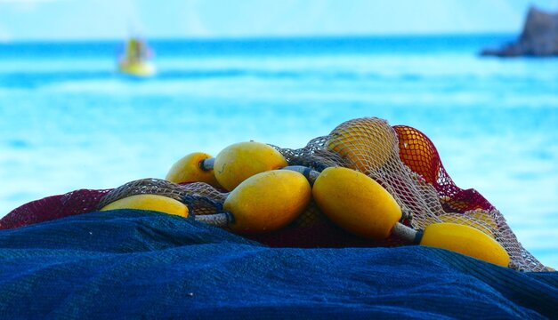 Fishing nets on the boat by the blue sea in Mediterranean city, nautical equipment background