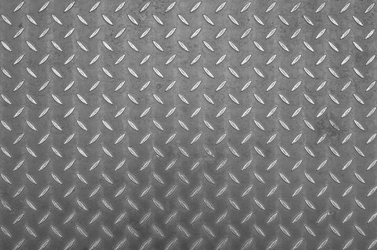 Horizontal close up of grey metal diamond plate texture background with anti slip pattern
