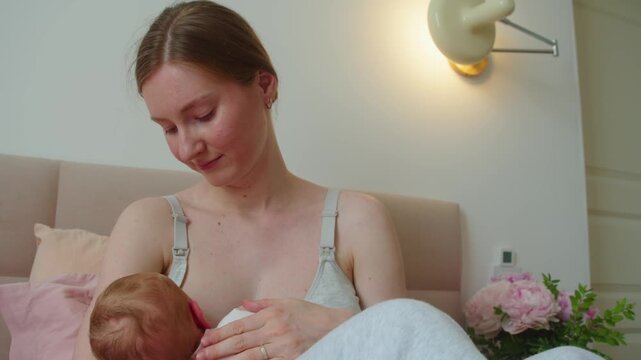 Mother encloses newborn in protective hold while breastfeeding. Feeding becomes more than nourishment, suggesting shelter, unconditional care, and maternal presence around vulnerable child.