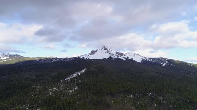 Cinematic aerial drone view reveals Mount Thielsen&rsquo;s isolated, needle-like summit rising above Oregon&rsquo;s Cascade forests, showcasing the extinct volcano&rsquo;s dramatic alpine profile.