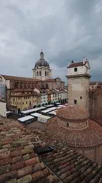 Panning shot of Mantova rooftops cityscape against dramatic sky with dark clouds, Lombardy, Italy