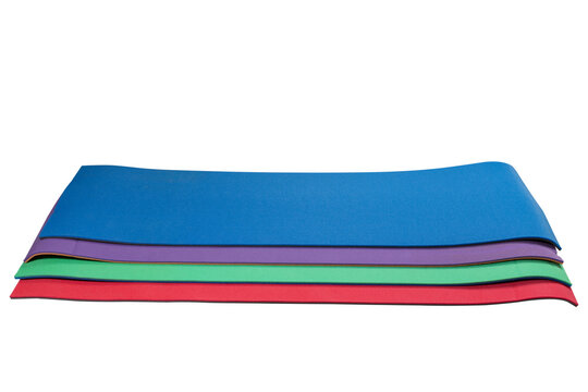 Stack of colorful yoga mats isolated on white background. Multi-colored fitness exercise mats for gymnastics, pilates, and home workout
