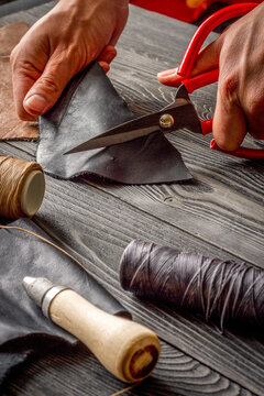 work in leather shop on dark wooden background close up