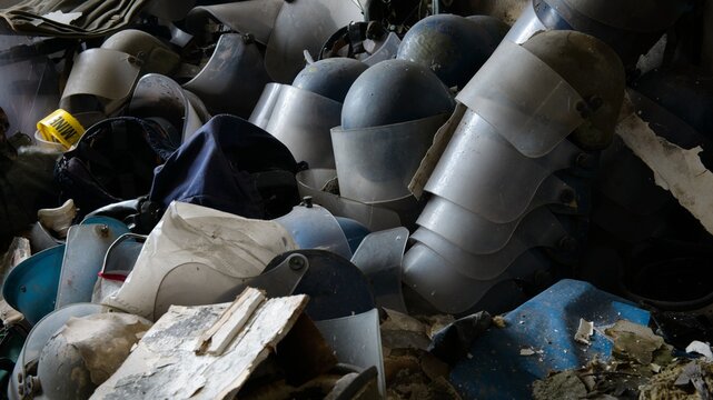 Pile of used dirty deminer helmets in abandoned building