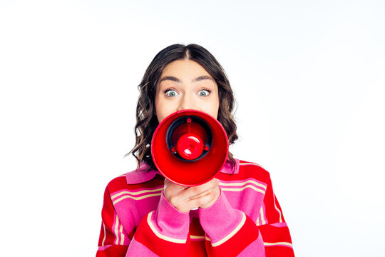 Young woman shouting into red megaphone to grab attention for announcement, promotion and communication campaign