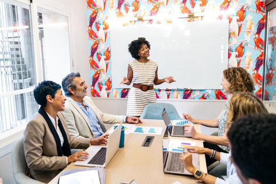 African american woman presenting ideas to multi ethnic colleagues during a professional business meeting in modern office