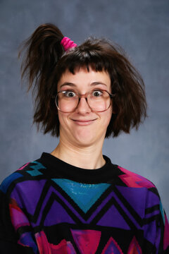 people of ai, yearbook photography of a person with short dark-brown bob with a high side ponytail, smug grin, wearing multicolor geometric sweater, 1980s portrait navy, photorealistic