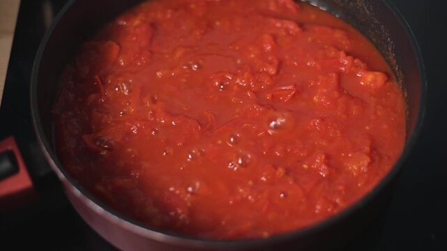 A pot of tomato sauce simmers on the stovetop, showing the transformation of raw ingredients into a rich mixture