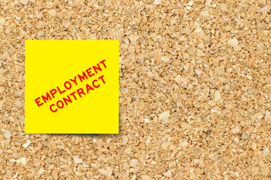 Yellow note paper with word employment contract on cork board background with copy space