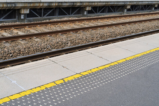 Steel tracks and a yellow-lined concrete platform at Forres station, Scotland