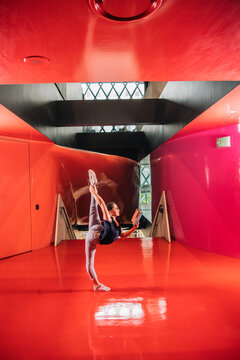 A woman stretches and reads a book inside a Seattle public library