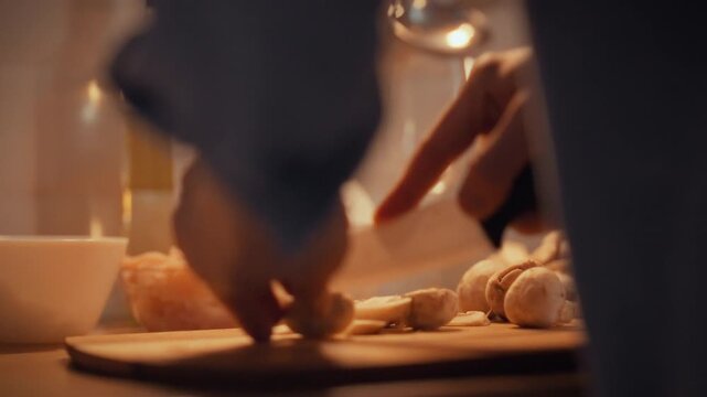 Slicing fresh champignon mushrooms on a spotless cutting board, a confident chef in a bustling kitchen deftly wields a white ceramic knife, showcasing precise cooking technique and culinary focus
