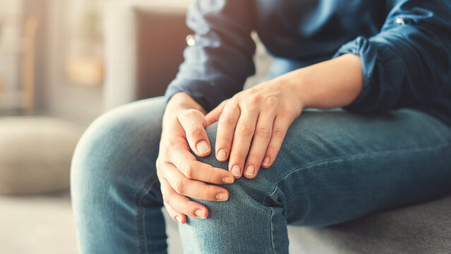 Young woman suffering from knee pain	
