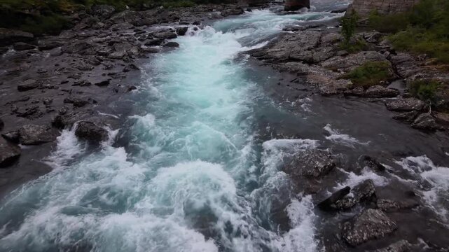 Aerial view of Maurvangsbrua bridge over the rushing river rapids with rocky banks in Tessanden, Innlandet, Norway.
