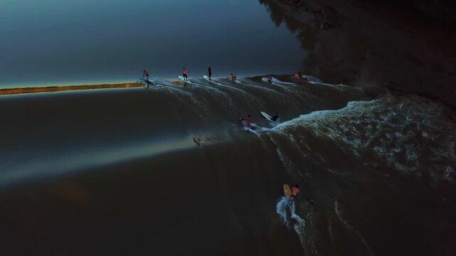Aerial view of surfers riding the Mascaret tidal bore wave on the Garonne river in Mascaret Podensac, Nouvelle-Aquitaine, France.