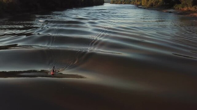 Aerial view of a small boat navigating the tidal bore on the Garonne river in Podensac, Nouvelle-Aquitaine, France.
