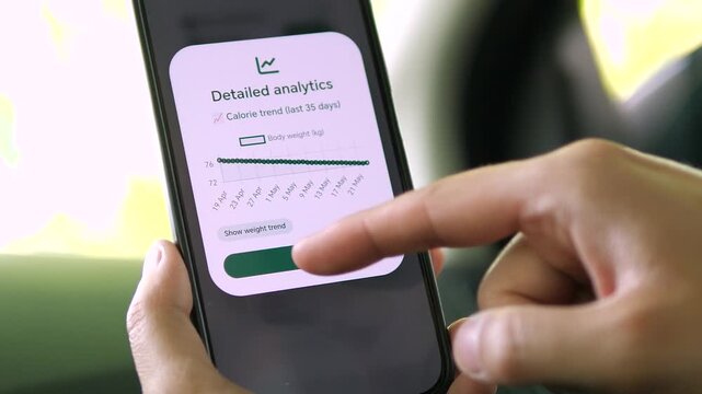 Mobile health app displaying a 35-day calorie trend graph. User toggles to view body weight progression. Perfect for fitness trackers, nutrition apps, and health analytics software B-roll.