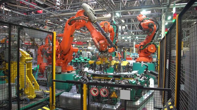 Advanced industrial robotic arms assembling car components inside modern manufacturing facility