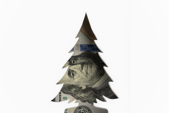 US one hundred dollar bill cut out in the shape of a Christmas tree isolated on white background