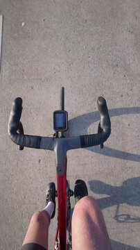 Top down POV of a road cyclist pedaling on smooth asphalt, capturing endurance cycling, fitness training, outdoor exercise and an immersive first person riding experience.
