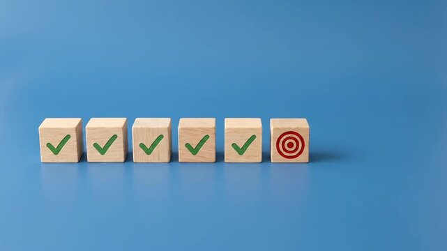Hand placing a target cube next to a row of completed checkmark blocks