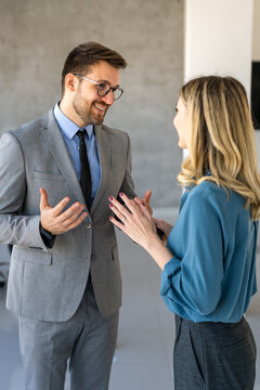 Professionals in a modern office environment discussing work-related matters