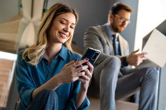 Two happy diverse multiethnic business team people working, talking in corporate office