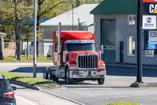 Gaspesie, Canada, 30 May 2026 : A red International semi-truck tractor unit is on a paved surface near a service building with Allison Transmission.